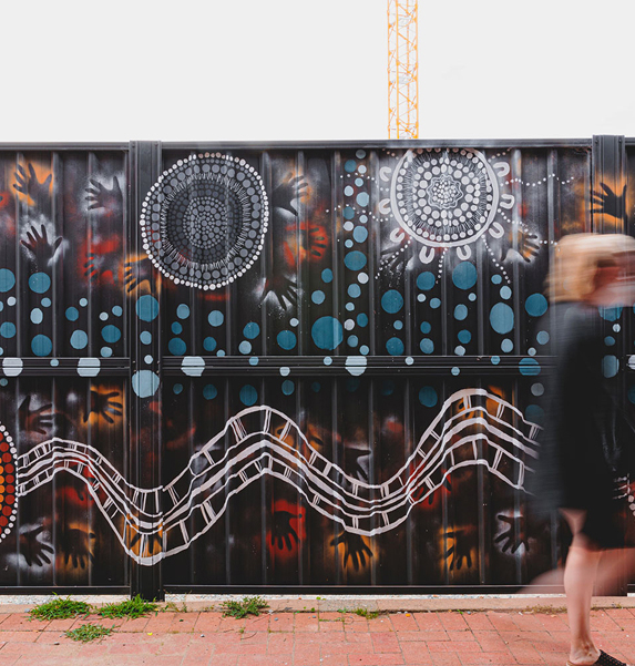 Aboriginal-inspired mural artwork on hoarding at TP Dynamics site