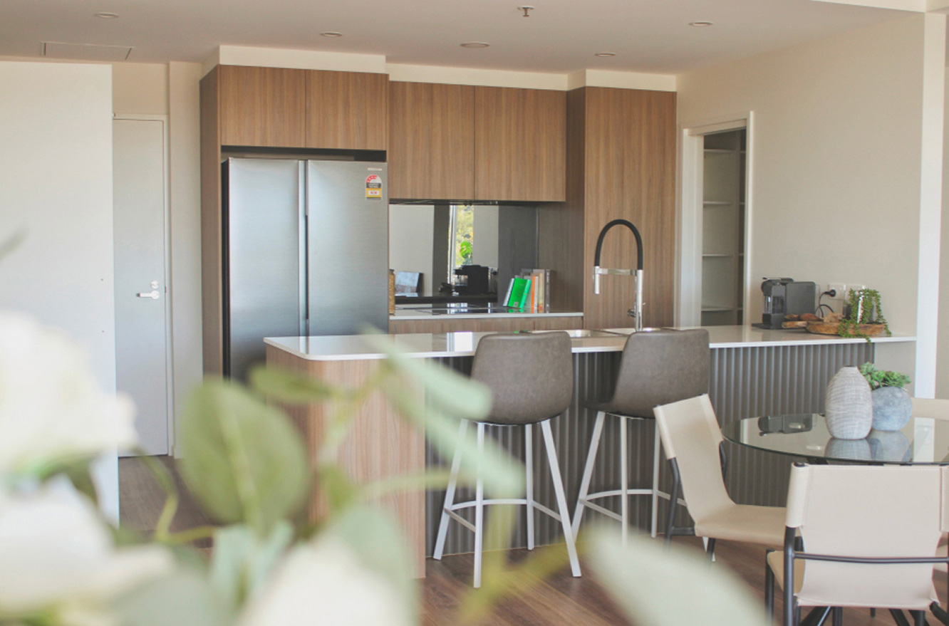 Modern G+ at Giralang kitchen with stone island, timber cabinetry and breakfast seating
