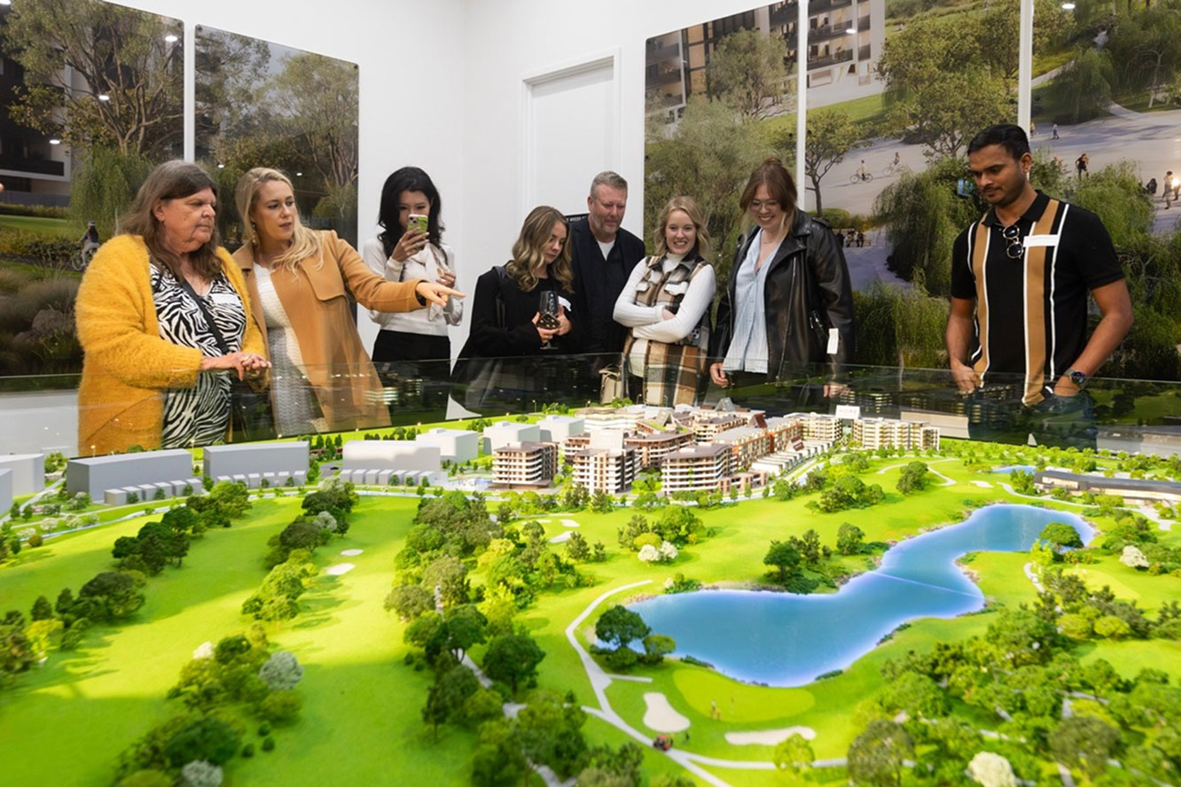 Visitors viewing scale model of Newlyne precinct at TP Dynamics Experience Centre in Lyneham