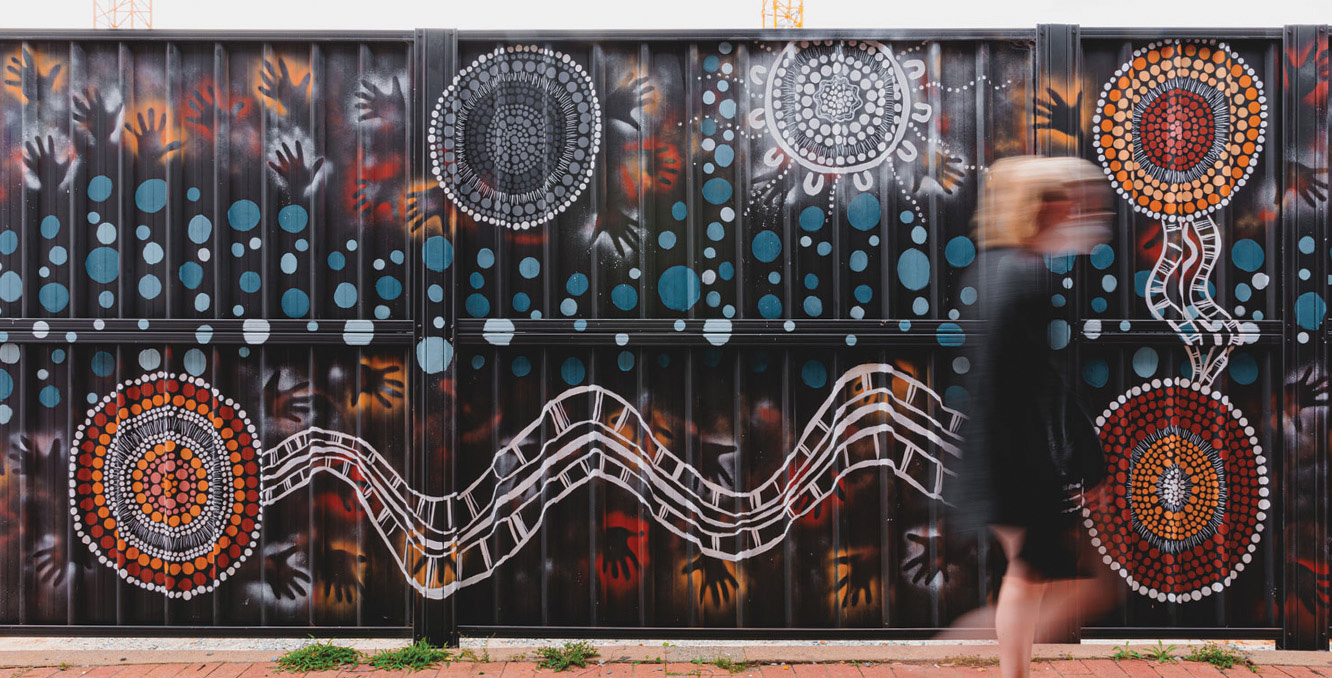 Aboriginal-inspired mural artwork on hoarding at TP Dynamics site