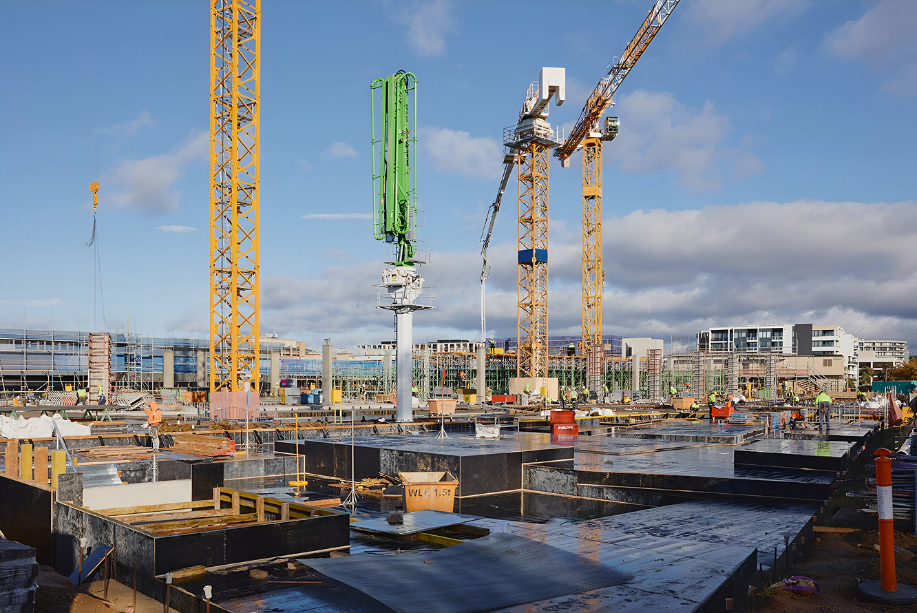 Construction progress at Dickson Village redevelopment site with cranes and foundations