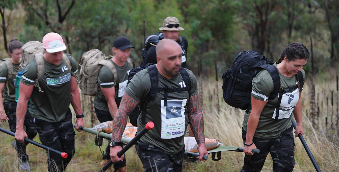Participants carrying weighted stretcher during Special Forces Challenge