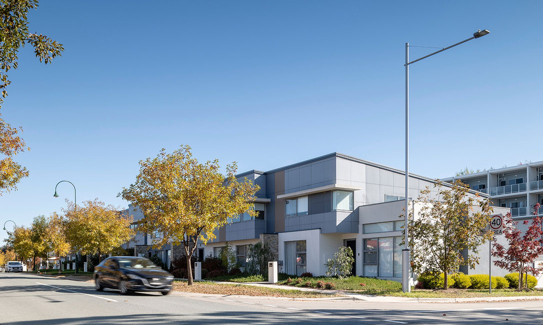 Modern Amaroo townhouse kitchen flowing to a private courtyard with double-glazed windows and year-round comfort