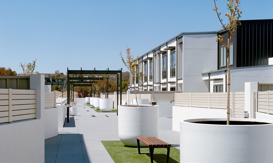 IVES by TP Dynamics – podium walkway with white planters, bench and pergola, Bruce, Canberra, Australia.