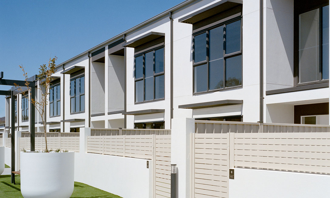 IVES by TP Dynamics – townhouse row with privacy fencing and planters, Bruce, Canberra, Australia.