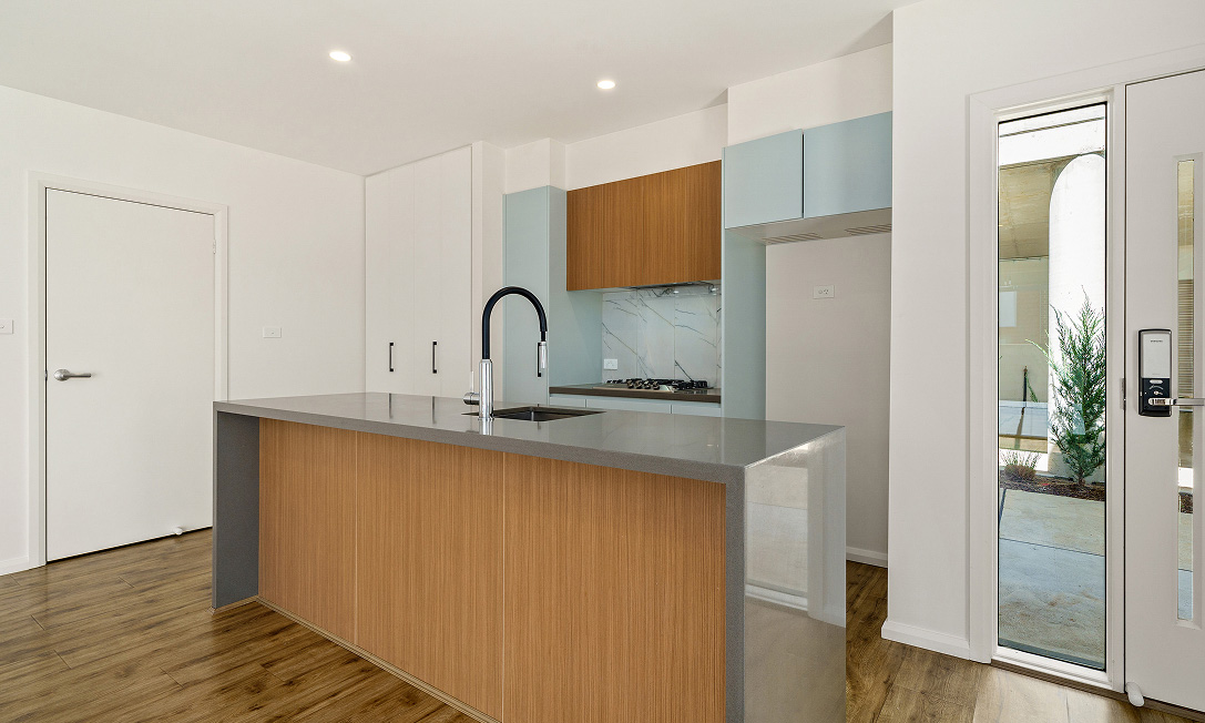Nest III townhouses in Lawson, Canberra — white facades, black-framed windows and timber cladding
