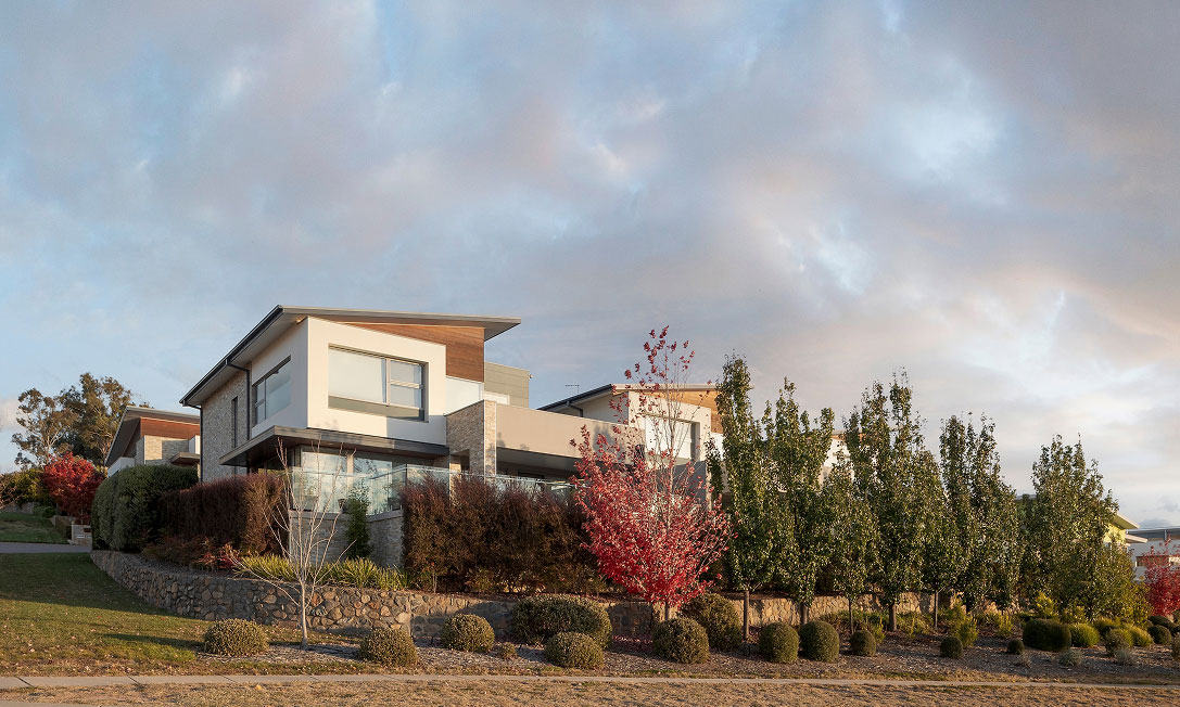 Hillcrest residence in North Weston, Canberra — freestanding home with white rendered upper level, natural stone detailing and floor-to-ceiling glazing by TP Dynamics